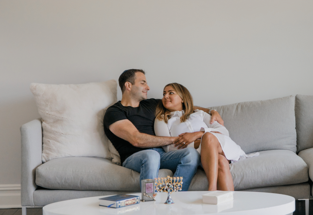 A couple holding hands on the couch