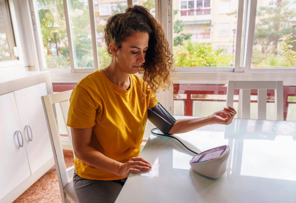 middle-aged woman checking her blood pressure at home